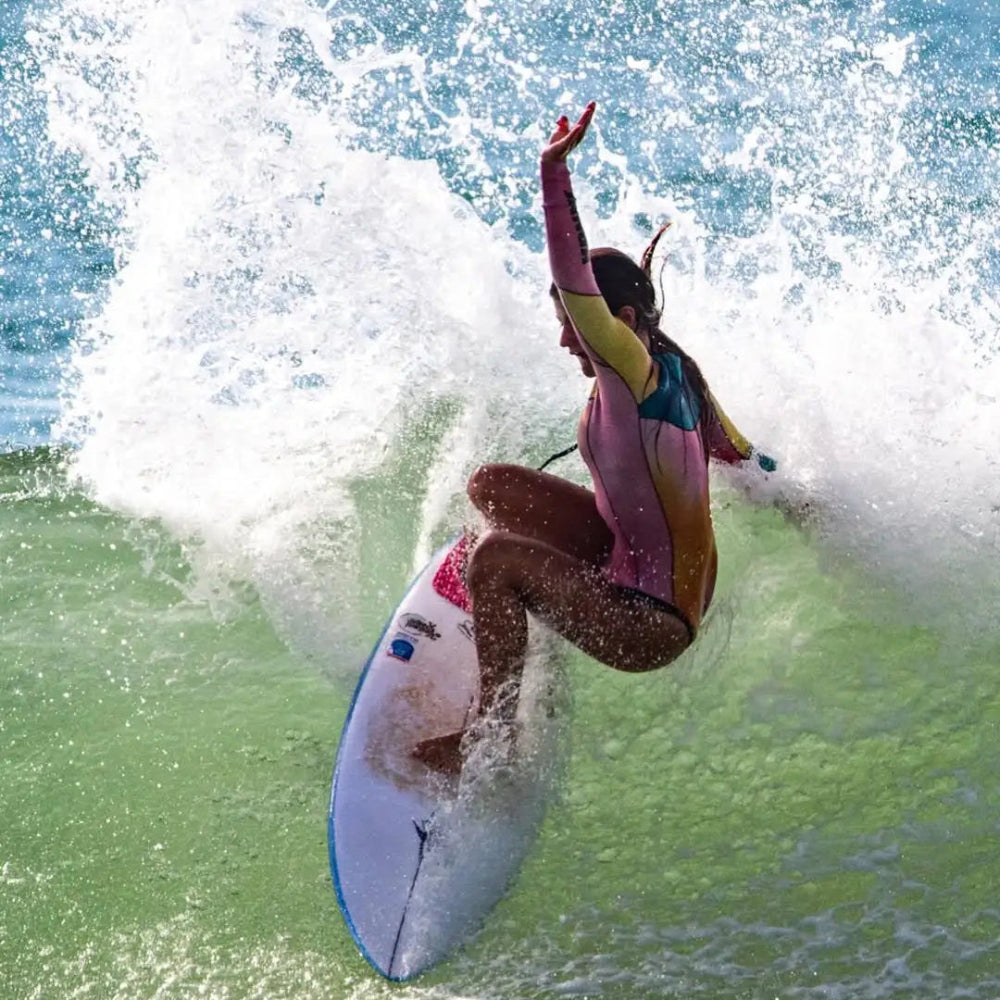 Surfer in a tie dye colorful wetsuit shorty