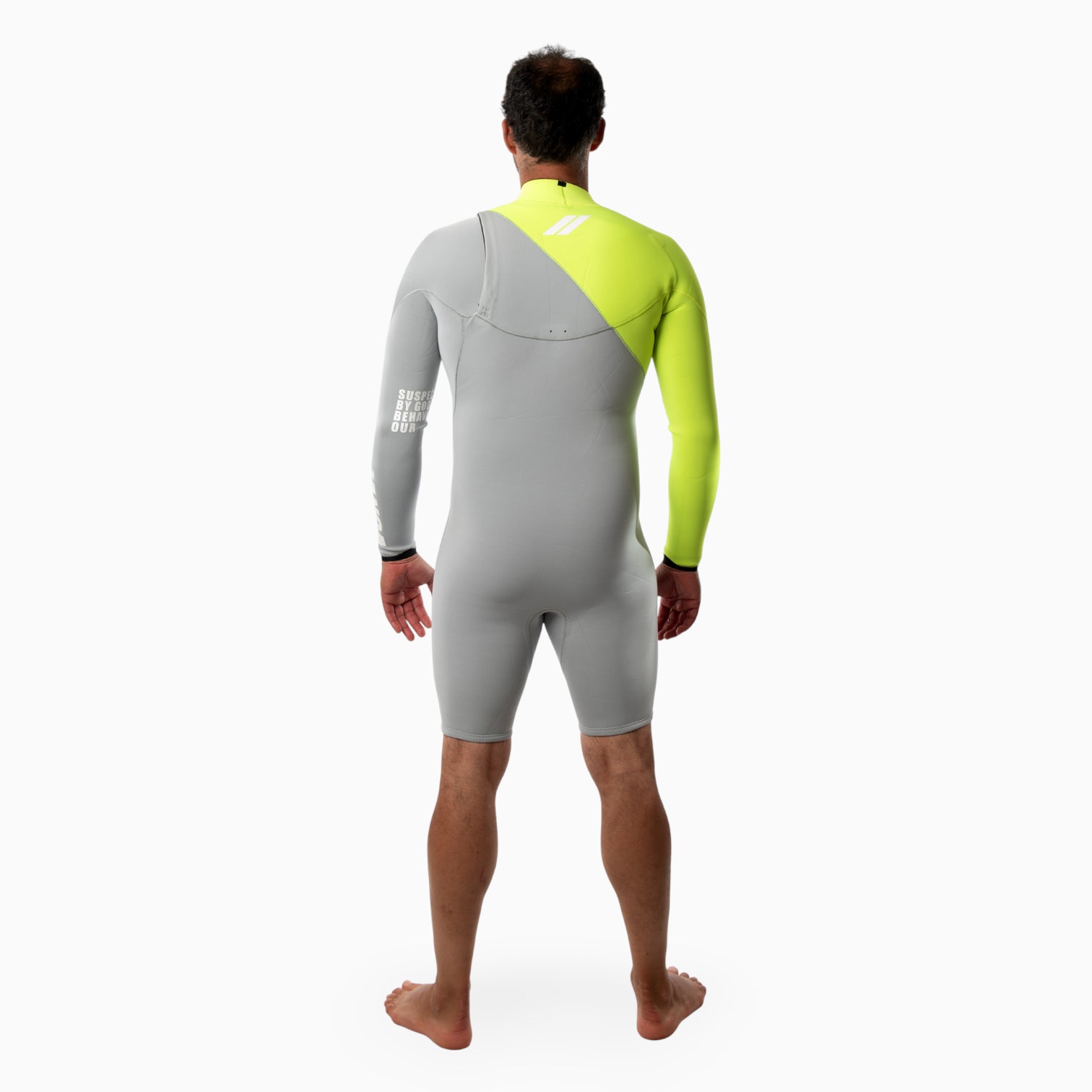 Surfer wearing a JANGA INDIGENT long sleeved spring gray and neon yellow wetsuit on a white background