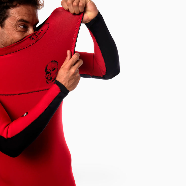 Surfer  wearing a JANGA DARK HALF red and black wetsuit on a white background zoom on no zip
