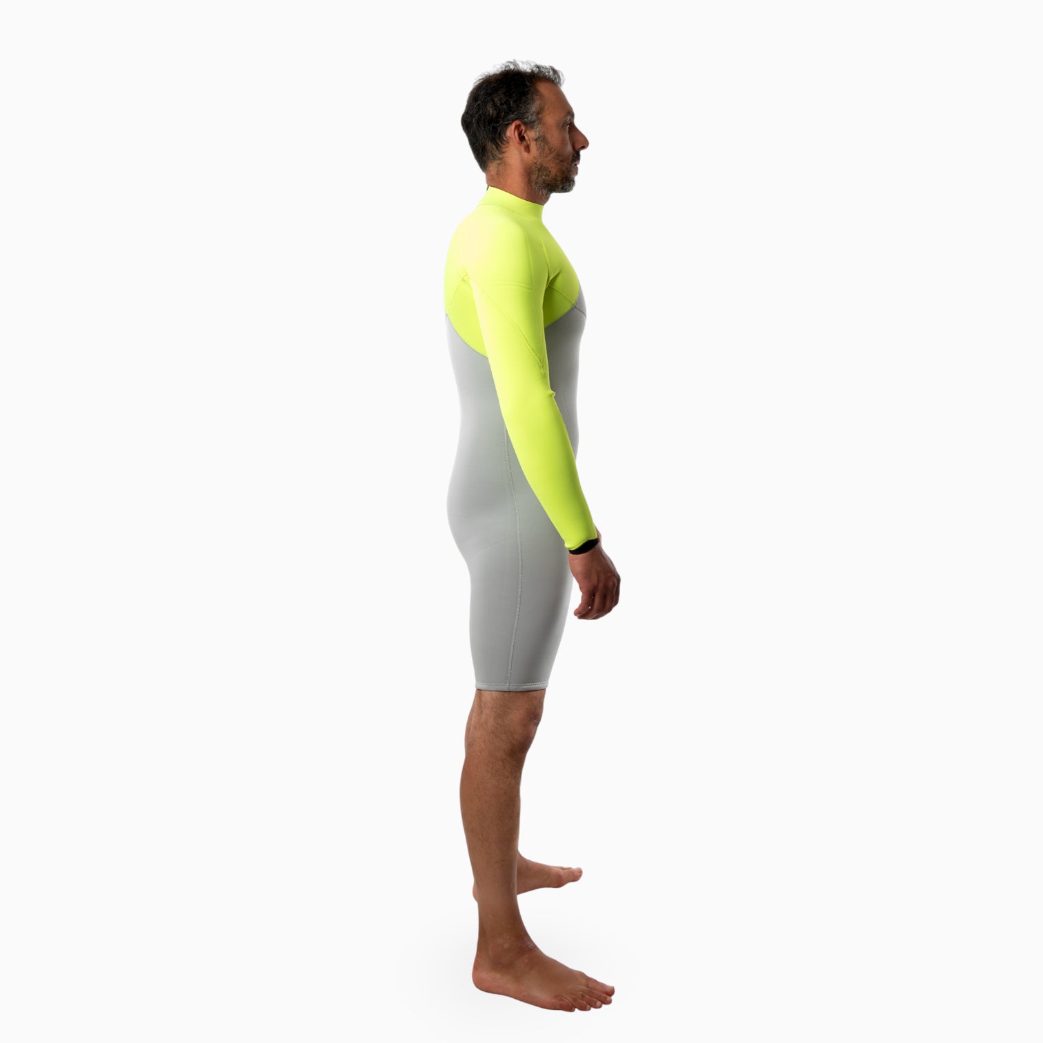 Surfer wearing a JANGA INDIGENT long sleeved spring gray and neon yellow wetsuit on a white background