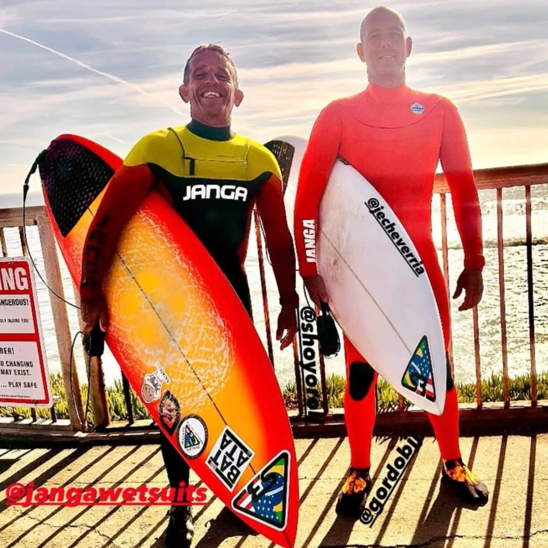 Two surfers in colorful JANGA wetsuits holding surfboards in Santa Cruz