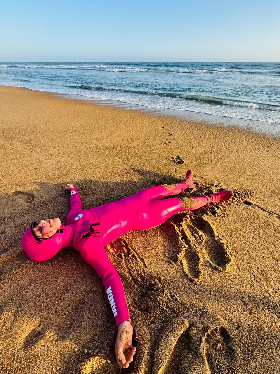 Kid wearing a pink JANGA kids hooded wetsuit 