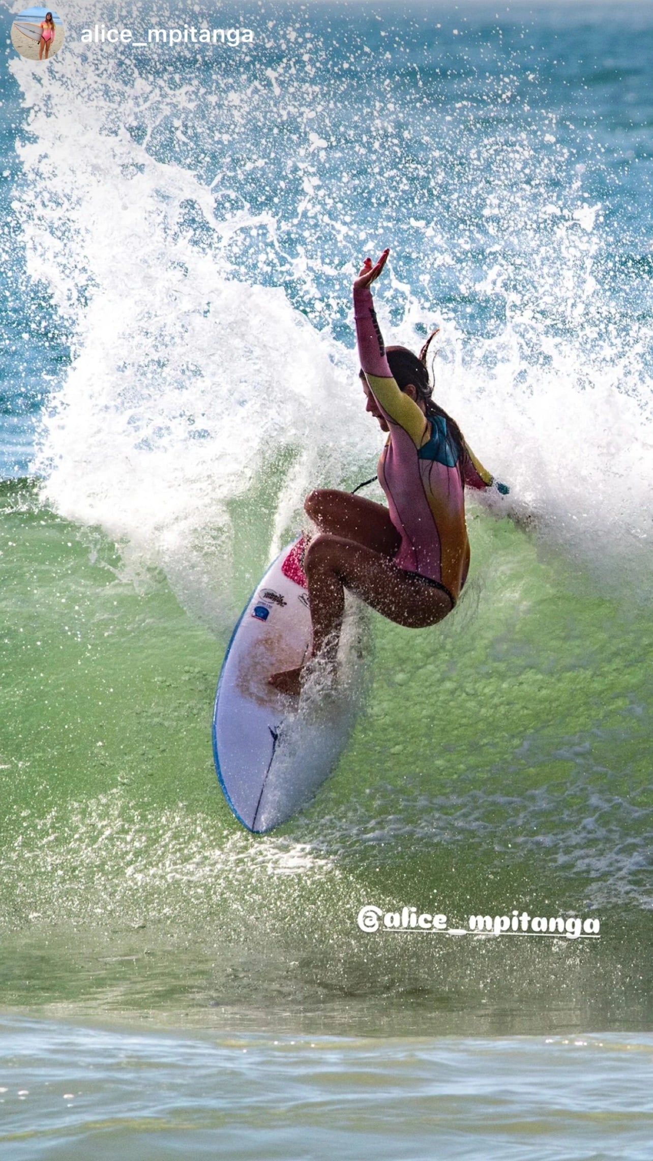 Surfer Alice Mpitanga in a tie dye colorful wetsuit shorty 