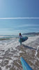 woman surfing in white and blue wetsuit